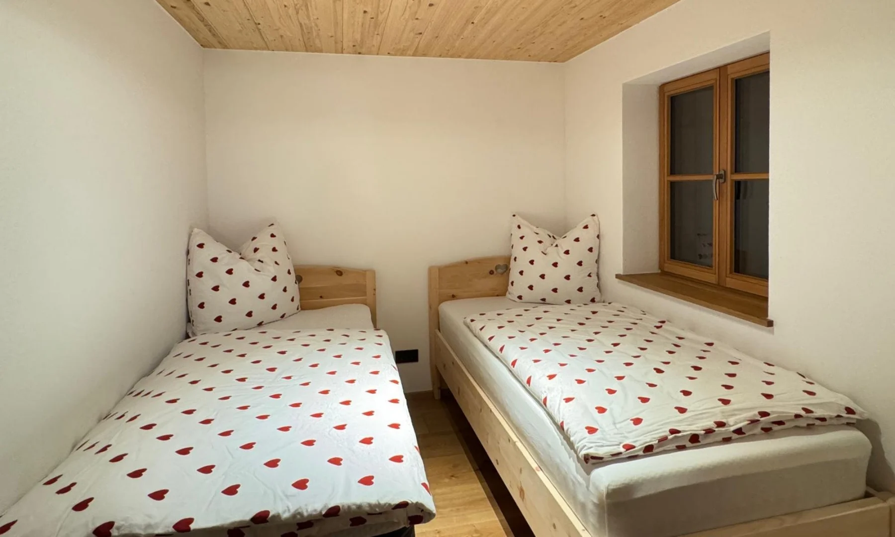 Kinder-Schlafzimmer der Zirben Suite mit zwei Einzelbetten und Herz-Bettwäsche