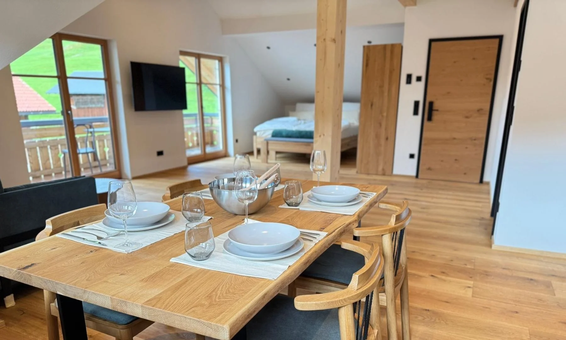 Gedeckter Esstisch aus Holz im offenen Wohnbereich der Berggold Suite mit Bergblick